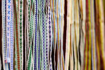 Details of a traditional colorful Lithuanian weave. Woven belts as a part of national Lithuanian costume sold on traditional Easter fair in Vilnius - obrazy, fototapety, plakaty