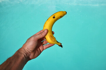 mão segurando banana, fruta  - obrazy, fototapety, plakaty