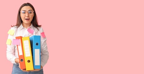 Stressed young businesswoman with sticky notes and document folders on pink background with space...