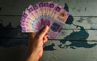 Hand holding new 50 peso bills
