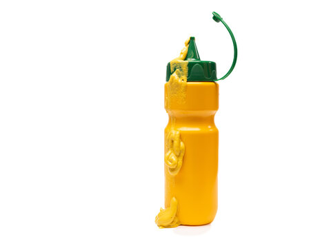 Plastic mustard squeeze bottle with mustard running down the front, isolated on white