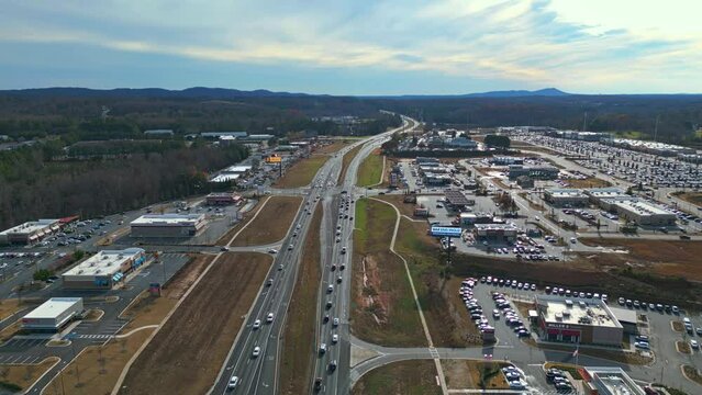 Slow traffic on american highway near Atlanta City with hills in background during sunny day - Aerial wide shot