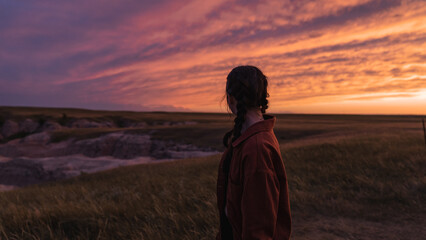 Woman looking out at Badlands sunset - Powered by Adobe