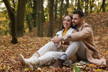 Fototapeta premium Romantic young couple spending time together in autumn park, space for text