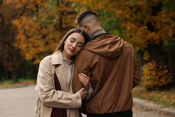 Happy young couple spending time together in autumn park