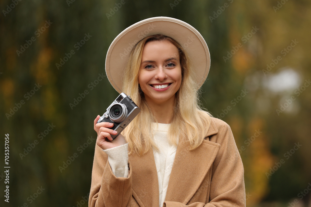 Wall mural Autumn vibes. Portrait of happy woman with camera outdoors