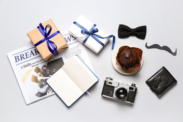 Paper mustache, notebook, muffin, gifts, newspaper and accessories on light background. Father's Day celebration