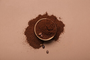 Bowl of coffee powder and beans on brown background