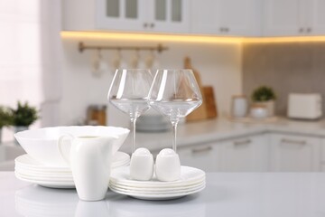Fototapeta na wymiar Set of clean dishware and glasses on table in kitchen, space for text