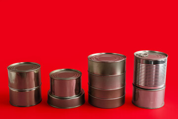 Stacks of tin cans with fish on red background