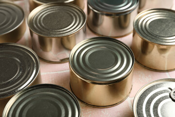 Many tin cans with fish on pink tiled table