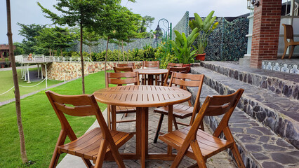 Row of round wooden tables with chairs in an outdoor cafe or restaurant with beautiful views of the surrounding nature