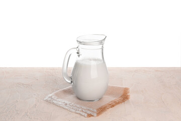 Jug of milk on table against white background