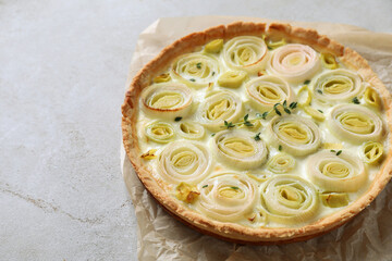 Tasty leek pie on grey textured table, closeup. Space for text