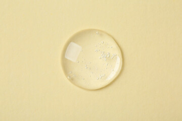 Sample of cosmetic serum on beige background, top view