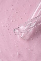 Pipettes with cosmetic serum on pink background, closeup