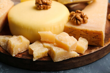 Plate with pieces of tasty cheese on table, closeup