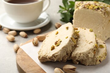 Tasty halva with pistachios served on grey table, closeup