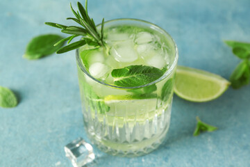 Glass of tasty mojito on blue background