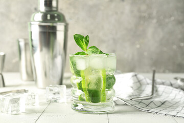 Glass of tasty mojito on table