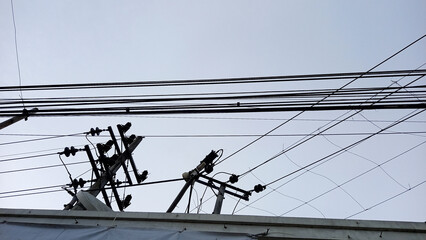 Dozens of electrical cables are tangled in a mess at the top of an electricity pole.