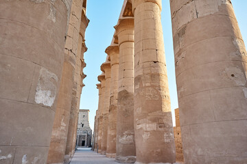 Majestic columns with ancient Egyptian drawings, sun comes out from behind the column. luxor Temple in Luxor, Egypt