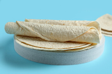 Board with thin lavash on blue background