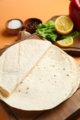 Boards with thin lavash on orange background