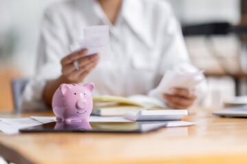 woman hand putting money coin into piggy for saving money wealth and financial concept.
