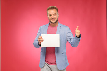 a man advertises a product service with a white box on a pink background