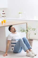 Young man having panic attack in kitchen