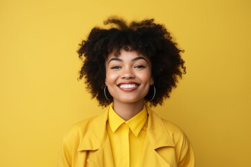 Happy african american woman with afro hairstyle on yellow background