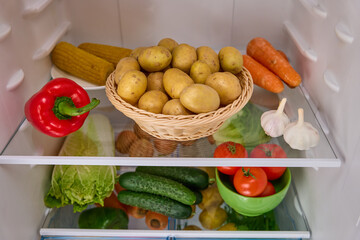 open refrigerator with organic potatoes basket 