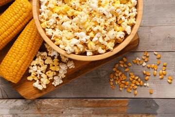 Bowl with tasty popcorn on grey wooden background