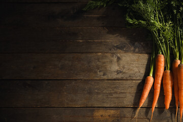 Fresh carrots with leaves on wooden background - obrazy, fototapety, plakaty
