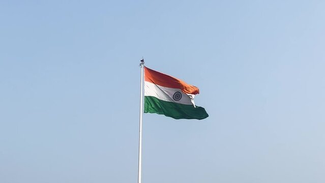 Indian national flag with tri color waving and flying high in the blue sky