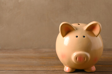 Piggy bank on brown wooden table near wall