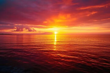 Obraz premium Fiery sunset over a calm ocean horizon