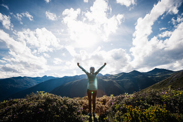Successful woman outstretched limbs at high altitude mountain peak - obrazy, fototapety, plakaty