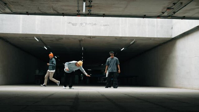 Group of hipster doing freeze pose while dancer team dancing together. Professional break dancer team perform street dance at building with funny and lively movement. Outdoor sport 2024. Sprightly.
