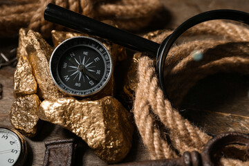 Fototapeta na wymiar Travel equipment, key and golden nuggets on brown wooden background