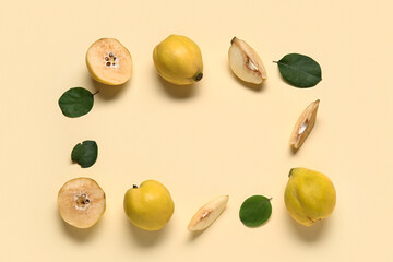 Frame made of sweet ripe quinces and leaves on yellow background