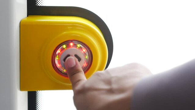 finger presses button to open doors in subway car.