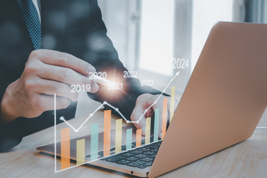 Businessman showing growing virtual holographic stock,positive indicators in 2024, businessman calculates financial data for long-term investments. on a dark background