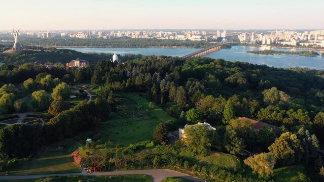 Aerial view of summer cityscape with residential buildings, green park and beautiful river. Kyiv, Ukraine.
