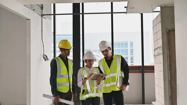 Engineer woman manager with Construction team uses tablets to check details of work and record data while inspecting construction work, Inspecting progress of work for planning and management.