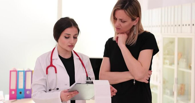 Gynecologist looks at child sonogram with serious expression