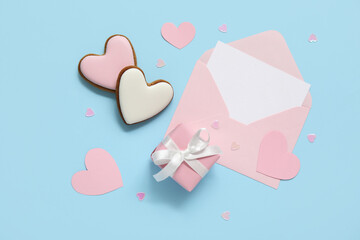 Heart shaped cookies with envelope and gift box on blue background. Valentine's Day celebration