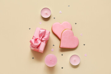 Heart shaped cookies with gift box and candles on yellow background. Valentine's Day celebration