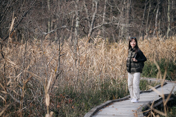 Nature's embrace, Asian traveler, a young Asian woman, revels in a solo hike along a scenic...